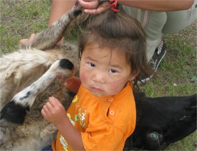 This small child has nothing better to do than hold the leg. It's difficult to say whether the child is a boy or girl.
