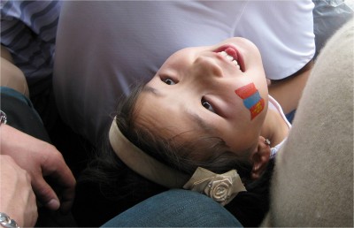 A little girl looking back at a relative during Naadam 2009.