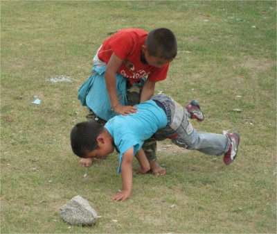 Like horseback riding, wrestling is a national sport, something that every Mongolian boy does. The rules are fairly simple. Whoever is taken down first loses. Feet and hands are about the only body parts that can touch the ground without being considered a takedown. You can see the boy in blue still has a chance as he keeps his balance.