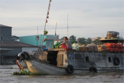Bamboo poles with items for sale hang on boats in the floating market. This makes finding a specific fruit or vegetable very convenient.