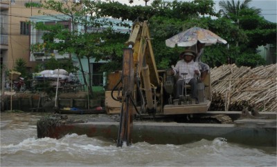 This was the first time I'd ever seen a floating backhoe. This big Caterpillar helps clear the debris and groom the marketplace routes in the shallow, soft Mekong Delta.